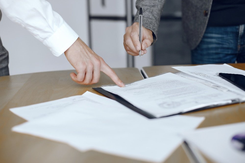 Asesoría Legal y Tributaria 3 hombres negocios sentados escritorio abogados personas que firman documentos importantes